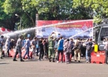 Water cannon menyemprotkan air untuk membubarkan massa saat Sispamkota di halaman Stadion Manahan Solo