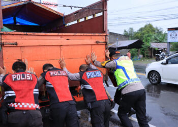 Kapolres Madiun Turun ke Jalan Saat Hujan, Bantu Atur Arus Balik dan Dorong Truk Mogok